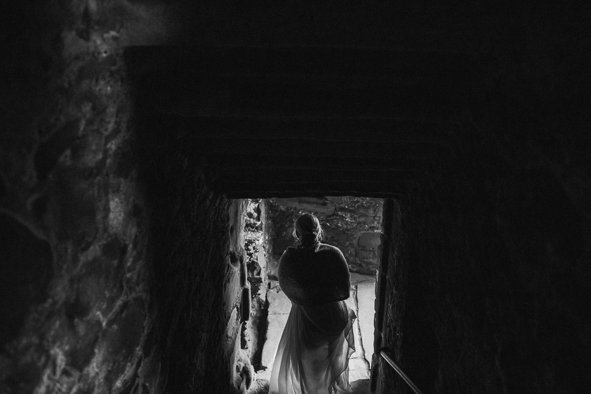 Black and white photo of the bride walking down the stairs