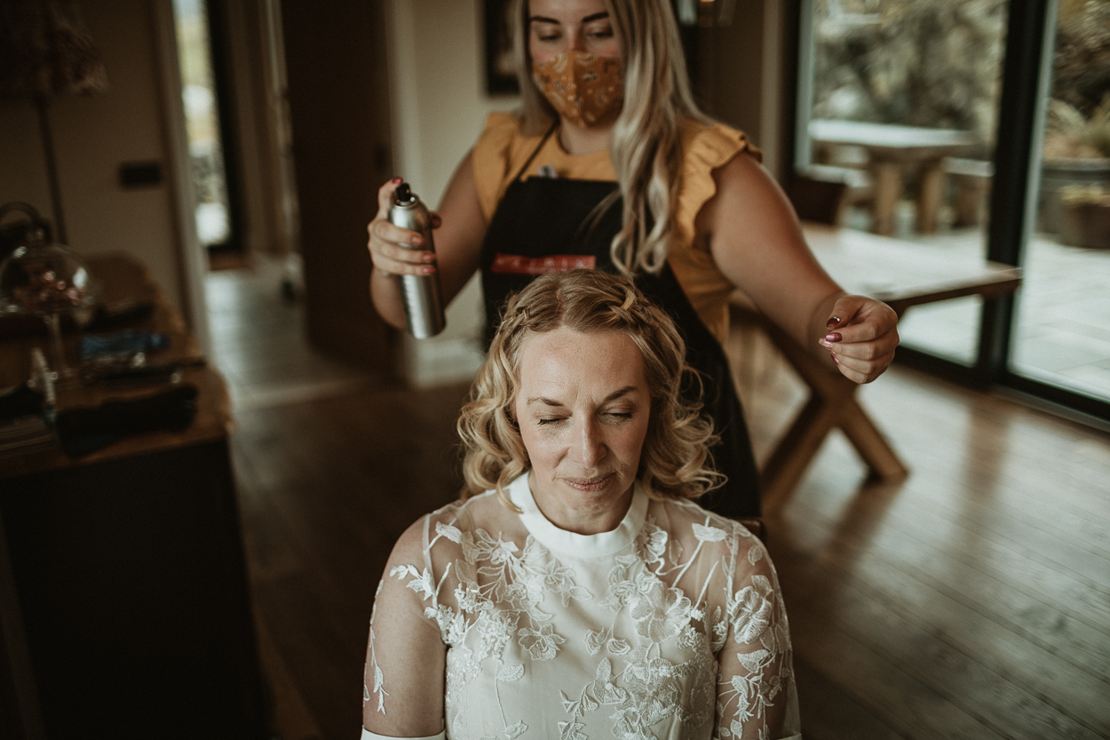 bride in a wedding dress having her hair done
